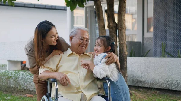 与孙子孙女一起坐在轮椅上的残疾爷爷和妈妈在公园里 快乐的亚洲三代家庭一起在户外后院玩乐 爷爷和小孩笑着 — 图库照片