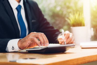 İşadamı muhasebe, masa başında dizüstü bilgisayar ve finans kavramını kullanarak çalışır.