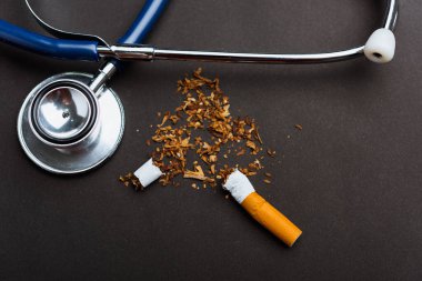 31 Mayıs Dünya Sigara Yok Günü, Sigara yok, kırık sigara veya tütün yığınının kapanışı ve fotokopi alanı olan siyah arka planda doktor steteskobu ve akciğer sağlığı konsepti