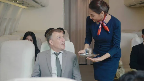 Flight attendant woman using digital tablet choose food order service businessman passenger on airplane