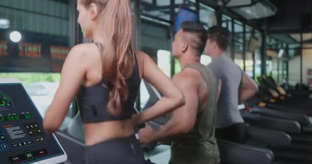 フィットネスジムクラブでのカーディオワークアウト中にマシントレッドミルで実行されている運動の若者のグループ スポーツ健康ライフスタイルの概念 — ストック動画