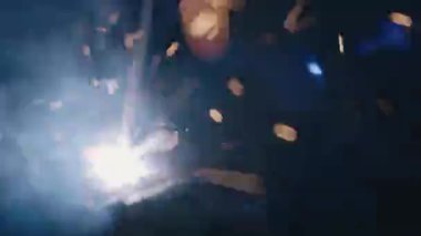 Elektrikli kaynak makinesi kullanan kapanış işçisi el işçiliği ile çelik kaynaklama, metal kaynak çeliği üretim fabrikasında kıvılcımlar saçtı.