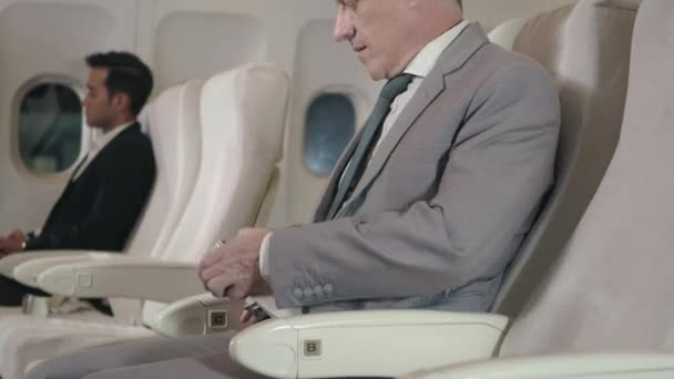 Літній Бізнесмен Кріпиться Ремінь Безпеки Сидінні Літаку Під Час Польоту — стокове відео