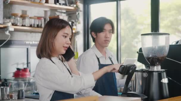 快乐的亚洲咖啡店女店员接到电话和预购咖啡的记录后 经理在咖啡店为小企业服务 — 图库视频影像