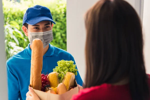 Азиатский Молодой Доставщик Форме Носить Защитную Маску Лица Делает Продуктовый — стоковое фото