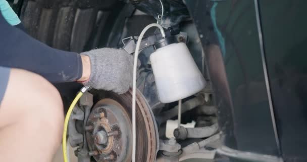 汽车修理工代替汽车上的制动液 技师从汽车修理厂的盘式制动器排气 汽车修理厂的汽车修理工 — 图库视频影像