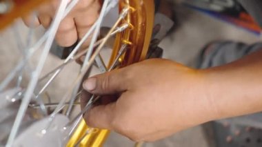 Motosiklet tekerinde çalışan teknisyenin çarkları var. Yeni çelik çarklar, motorsiklet çarkları, tekerlek hizalama aletleri.