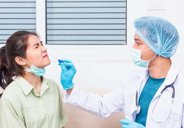 コロナウイルス検査 医師男性はアジアの若い女性からコロナウイルス検査を確認するために綿棒で鼻を通って唾液サンプルを取ります Covid 19パンデミック発生医学と医療概念 — ストック写真