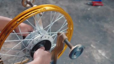 Motosiklet tekerinde çalışan teknisyenin çarkları var. Yeni çelik çarklar, motorsiklet çarkları, tekerlek hizalama aletleri.