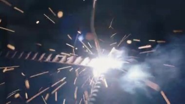 Elektrikli kaynak makinesi kullanan kapanış işçisi el işçiliği ile çelik kaynaklama, metal kaynak çeliği üretim fabrikasında kıvılcımlar saçtı.