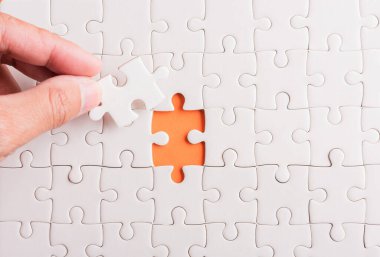 Top view düz konum son parça beyaz kağıt yapboz oyunu çözülmesi için yerleştirilen son parçalar tam görev, turuncu arka plan üzerine stüdyo çekimi, sınav hesaplama konsepti