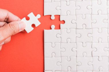 Üst görünüm düz konum son parça beyaz kağıt yapboz oyunu çözülmesi için yerleştirilen son parçalar tam görev, pembe arka plan üzerine stüdyo çekimi, quiz hesaplama konsepti