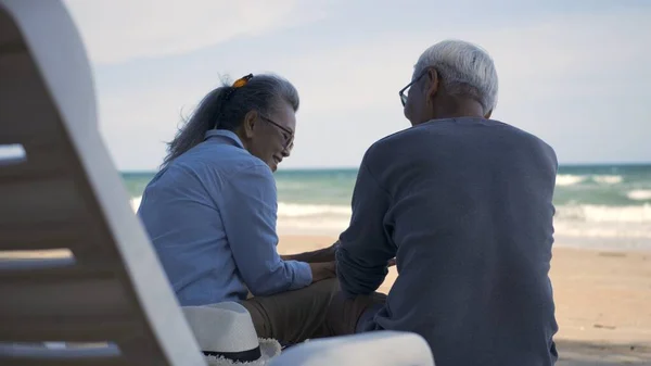 幸せなアジアの家族は 高齢者のカップルが一緒に話してビーチ旅行休暇に背を向けて椅子に座って ロマンチックな高齢者をお楽しみください旅行夏休み 計画生命保険退職カップルのコンセプト — ストック写真