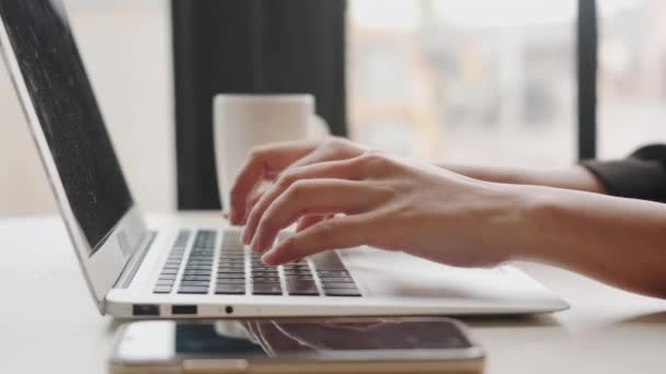 ノートパソコンのキーボードで入力する仕事をしているサラリーマンの女性 ノートパソコンを使いながら忙しい若い女性 喫茶店の女性のワークスペース — ストック動画