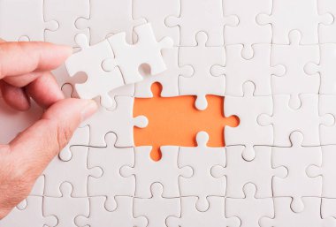 Top view düz konum son parça beyaz kağıt yapboz oyunu çözülmesi için yerleştirilen son parçalar tam görev, turuncu arka plan üzerine stüdyo çekimi, sınav hesaplama konsepti
