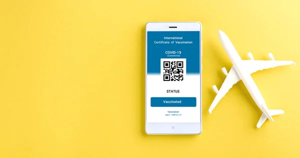 Modellflugzeug Und Immunitätsausweis Sind Auf Dem Smartphone Auf Gelbem Hintergrund — Stockfoto