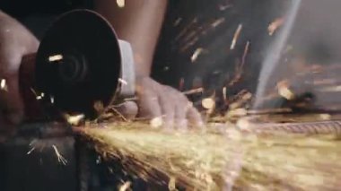 Elektrikli tekerlek öğütme ve çelik yapıyı kesme kullanan işçiler, endüstriyel üretim çarkından kıvılcımlar çıkardılar.