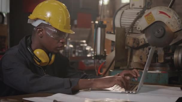 Hombre Joven Trabajador Negro Industrial Estadounidense Con Casco Amarillo Teclado — Vídeos de Stock