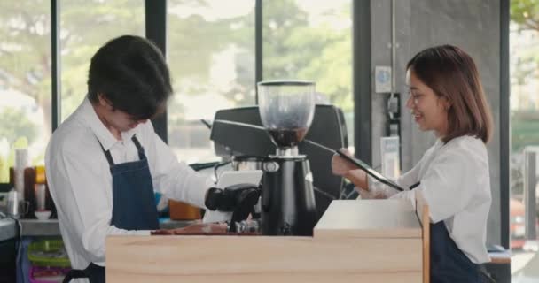 在咖啡店的柜台边工作时 年轻貌美的女士和身穿围裙的英俊男士在一起聊天 这是店主的小商业理念 — 图库视频影像