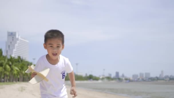 Glad Liten Pojke Leker Med Leksak Flygplan Flyg Tropisk Strand — Stockvideo