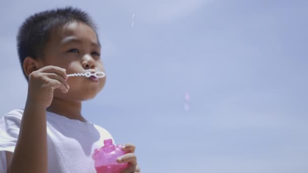 快乐的小男孩在吹肥皂泡 有趣的孩子在夏天在海滩上吹了很多泡沫 — 图库视频影像