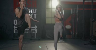 İki kaslı genç beyaz adam ve Asyalı kadın gülme egzersizi yapıyorlar vücut geliştiriciler spor salonunda antrenman yapıyorlar sağlık kulübünde sağlıklı çiftler için spor yapıyorlar.