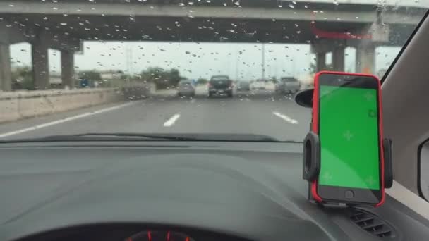 車のダッシュボードで携帯電話のホルダーにマウントされている現代のスマートフォンの緑の画面デバイスガジェットの地図のGpsナビゲーションは 目的地に行く高速道路で運転を行う — ストック動画