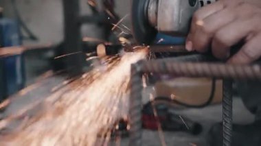 Elektrikli tekerlek öğütme ve çelik yapıyı kesme kullanan işçiler, endüstriyel üretim çarkından kıvılcımlar çıkardılar.