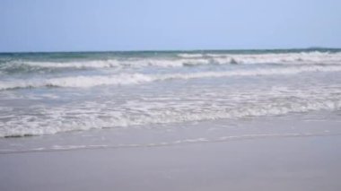 Güzel tropikal plaj beyaz kum turkuvaz okyanus suyu ve mavi gökyüzü güneşli yaz tatili gününde, manzara manzarası