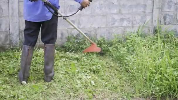 Arbetare Man Bära Stövlar Klippa Gräsmatta Med Gräs Trimmer Utomhus — Stockvideo