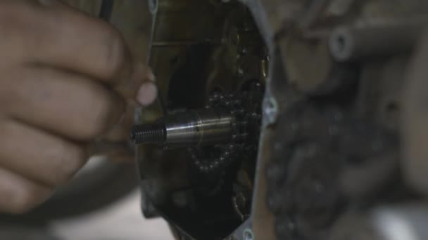 オートバイのエンジンの整備士のチェーン磁気ホイールに置かれた機械 店内のバイク 自動バイクの修理 — ストック動画