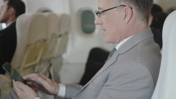 Glücklicher Geschäftsmann Mit Wifi Sms Oder Handy Spielen Flugzeug Sitzt — Stockvideo