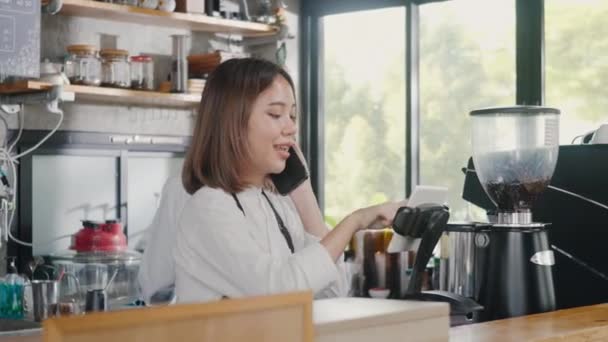 快乐的亚洲咖啡店女店员接到电话和预购咖啡的记录后 经理在咖啡店为小企业服务 — 图库视频影像