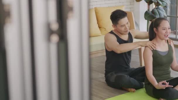 幸せなアジアの美しいライフスタイルの家族のカップル 女性は自宅で蓮のポーズのワークアウトとリラックスのための男性マッサージ肩に瞑想ヨガを行う スポーツの健全なコンセプト — ストック動画