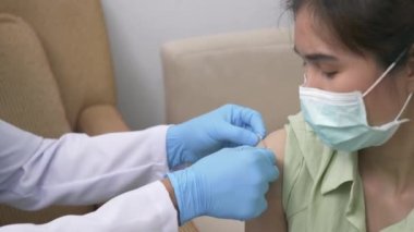 Aşı, Doktor Bey genç bir kadının omzuna koronavirüs aşısı yaptıktan sonra lastik koruyucu eldivenler yapıştırıcı bandaj sıva, Covid-19 İlaç ve Sağlık Konsepti koyuyor.