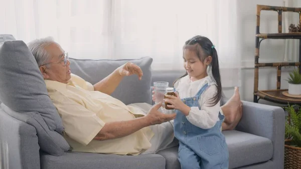 Asiatico Nipote Portato Medicina Acqua Nonno Mangiare Sul Divano Nel — Foto Stock