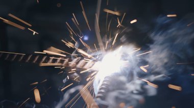Elektrikli kaynak makinesi kullanan kapanış işçisi el işçiliği ile çelik kaynaklama, metal kaynak çeliği üretim fabrikasında kıvılcımlar saçtı.