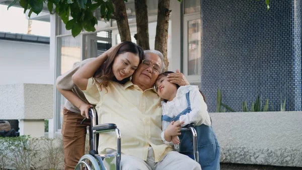 与孙子孙女一起坐在轮椅上的残疾爷爷和妈妈在公园里 快乐的亚洲三代家庭一起在户外后院玩乐 爷爷和小孩笑着 — 图库照片