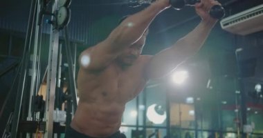 Trisepsler için egzersiz yapan kaslı bir adam halterciyi ağırlık kaldırma makinesiyle ağırlık kaldırarak spor salonunda kaslarını esnetmeye zorlar spor formundaki vücut geliştirme konsepti
