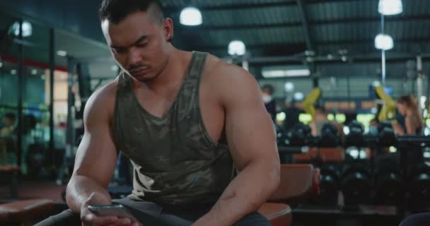 Aktiver Junger Mann Unterbricht Sitzen Mit Smartphone Nach Workout Training — Stockvideo