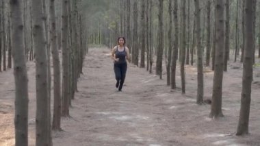 Genç bir bayan, Forest Spring Park açık hava tropikal orman patikasında spor antrenmanı koşucusu, formda vücut koşusu egzersizi, kilo kaybı sağlıklı ve yaşam tarzı konsepti olan kadın model.