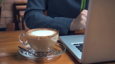 İş kadını elinde akıllı telefon tutuyor ve dizüstü bilgisayarda klavye yazıyor. Evde çalışıyor, blog yazarı kadın iş yerindeki kahve dükkanında internet tarayıcı bilgilerini kullanıyor.