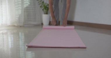 Spor hazırlıklarından önce ya da sonra salonda egzersiz yapan, spor salonunda egzersiz yogası yapan, covid19 salgını sırasında egzersiz yapan sağlıklı yaşam tarzı konsepti olan pembe yoga minderi kullanan bir adam.