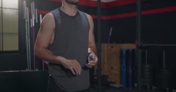 근육질인 남자가 보디빌더 운동을 준비하기 발톱으로 손뼉을 — 비디오