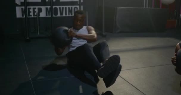 若い筋肉運動黒の男はフィットネスジムで医療ボールで動作腹部の練習を行う 強さのワークアウト健康的なライフスタイルスポーツの概念 — ストック動画