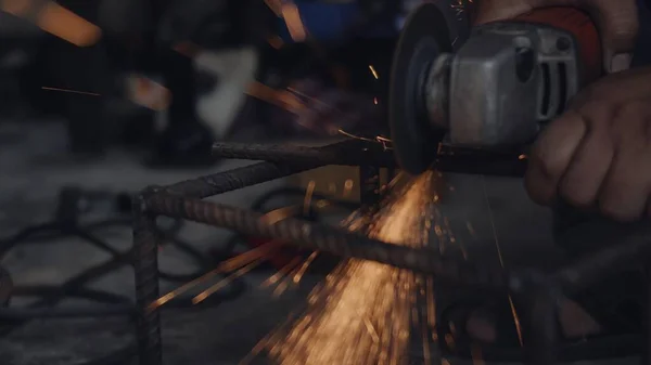 바퀴를 사용하여 마찰을 일으키고 구조를 절단하는 노동자는 공업에서 연마석에서 스파크를 — 스톡 사진