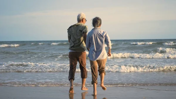 아시아의 활동적 해변으로 달려가 즐겁고 낭만적 노인들은 방학을 즐기고 부부에게 — 스톡 사진