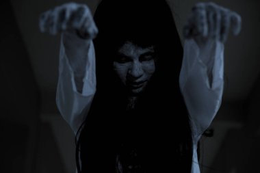 Korkunç kadın hayalet duruşu. İki elini eve koy, Cadılar Bayramı konsepti.