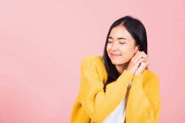Mutlu Asyalı portre güzel sevimli genç neşeli melez kadın gülümse utangaç yüz ifadesi, stüdyo çekimi izole pembe arka plan, Taylandlı kadın utangaç zevk iki elini de yüze koy, kopyala boşluk