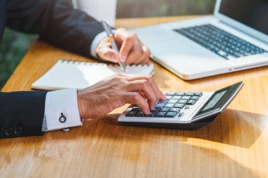 İşadamı muhasebe, masa başında dizüstü bilgisayar ve finans kavramını kullanarak çalışır.